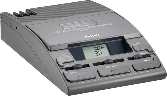 Un dispositivo di registrazione grigio con display, tasti per la riproduzione, avanzamento/riavvolgimento e volume. Iscrizione: '720 Transcription System'.
