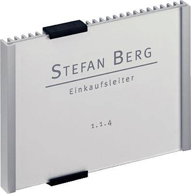 Targhetta con su scritto 'Stefan Berg, Responsabile Acquisti, 1.1.4' su uno sfondo metallico.