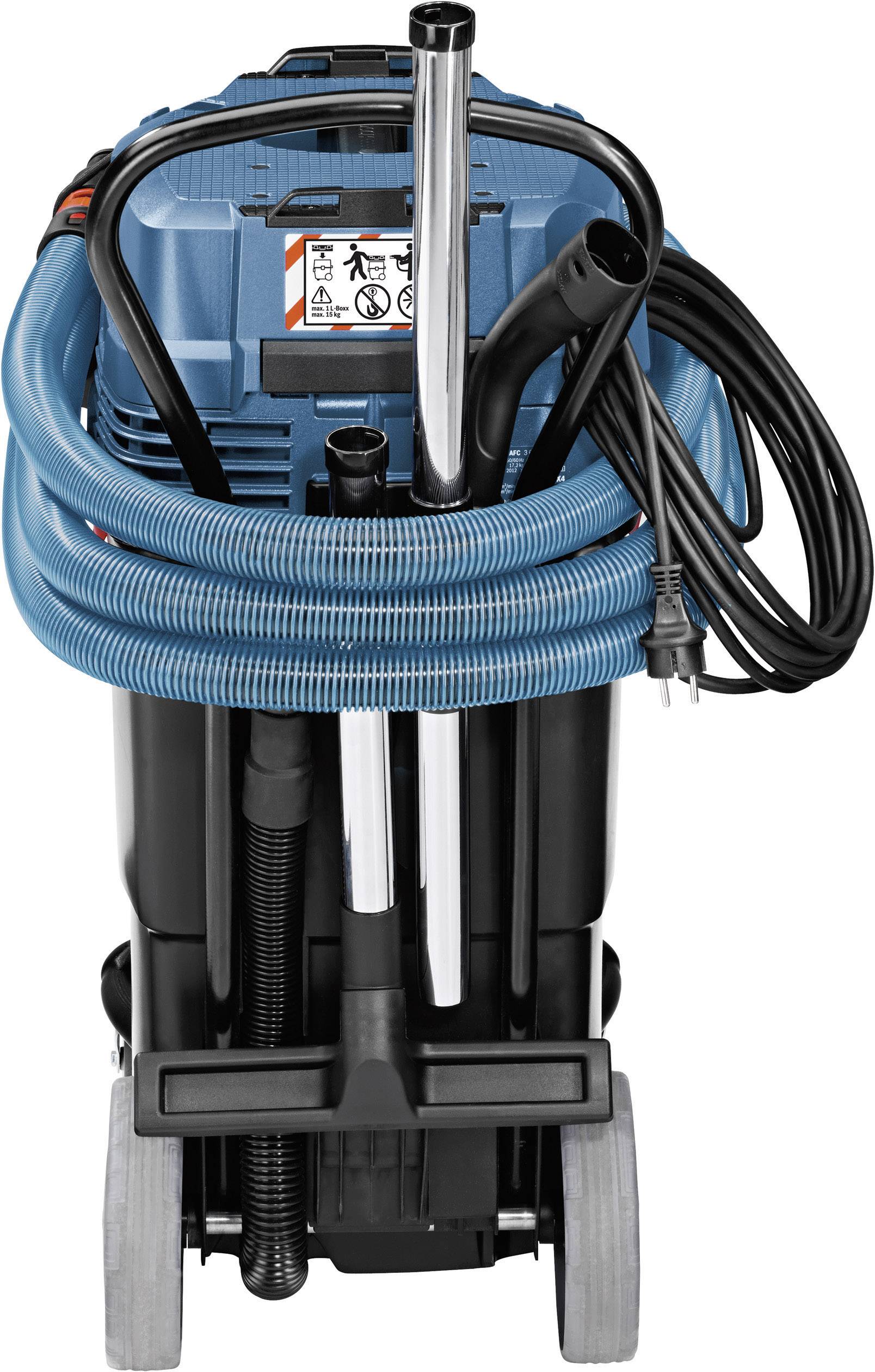 Aspirapolvere con tubo blu e involucro nero, due tubi metallici, cavo elettrico e ruote. Davanti è presente un avviso di attenzione.