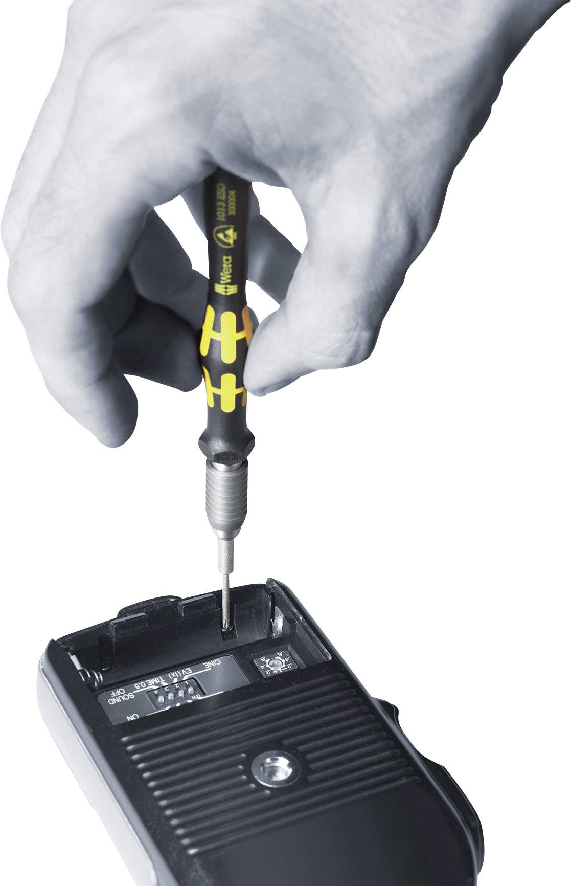 Mano che tiene un cacciavite, rimuove una vite dal vano batteria di un dispositivo.