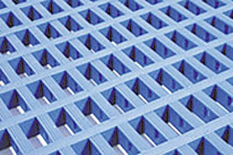 Un primo piano di una griglia blu con aperture quadrate regolari disposte in un motivo geometrico.