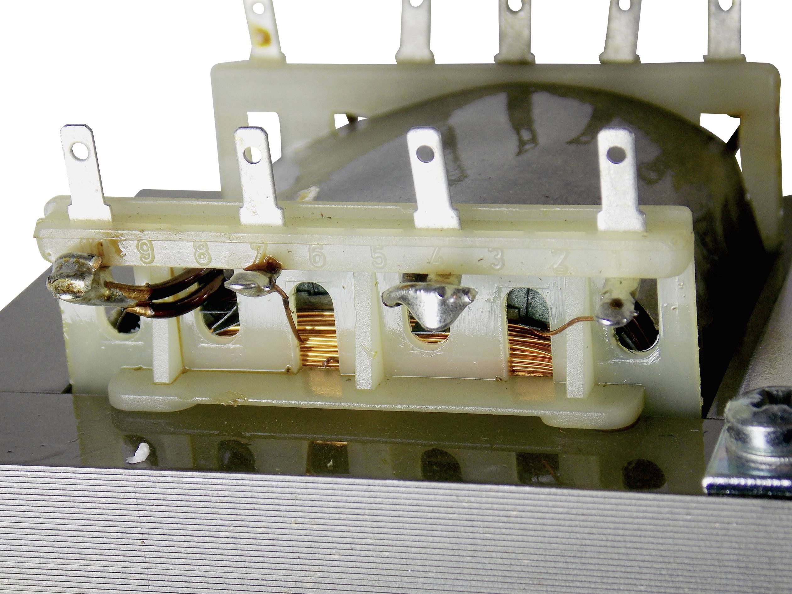 Un trasformatore con più connettori metallici e avvolgimenti in rame visibili, montato su una base metallica.