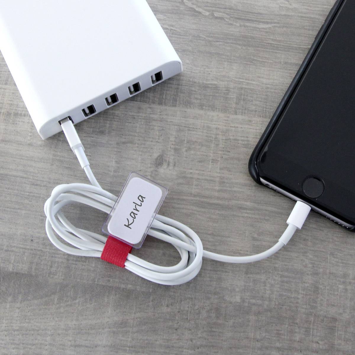 Una powerbank sta caricando uno smartphone. Un cavo con la scritta 'Kama' è avvolto, mentre l'hub USB offre più porte.