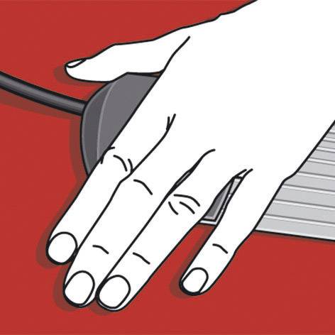 Una mano tocca un mouse su un tavolo rosso.