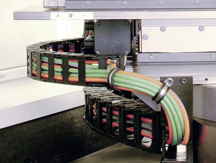 Braccio di un robot industriale con cavi colorati in una catena portacavi.