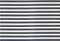 Dodici strisce metalliche disposte in parallelo con bordi dentellati, probabilmente lame di sega, su uno sfondo chiaro.