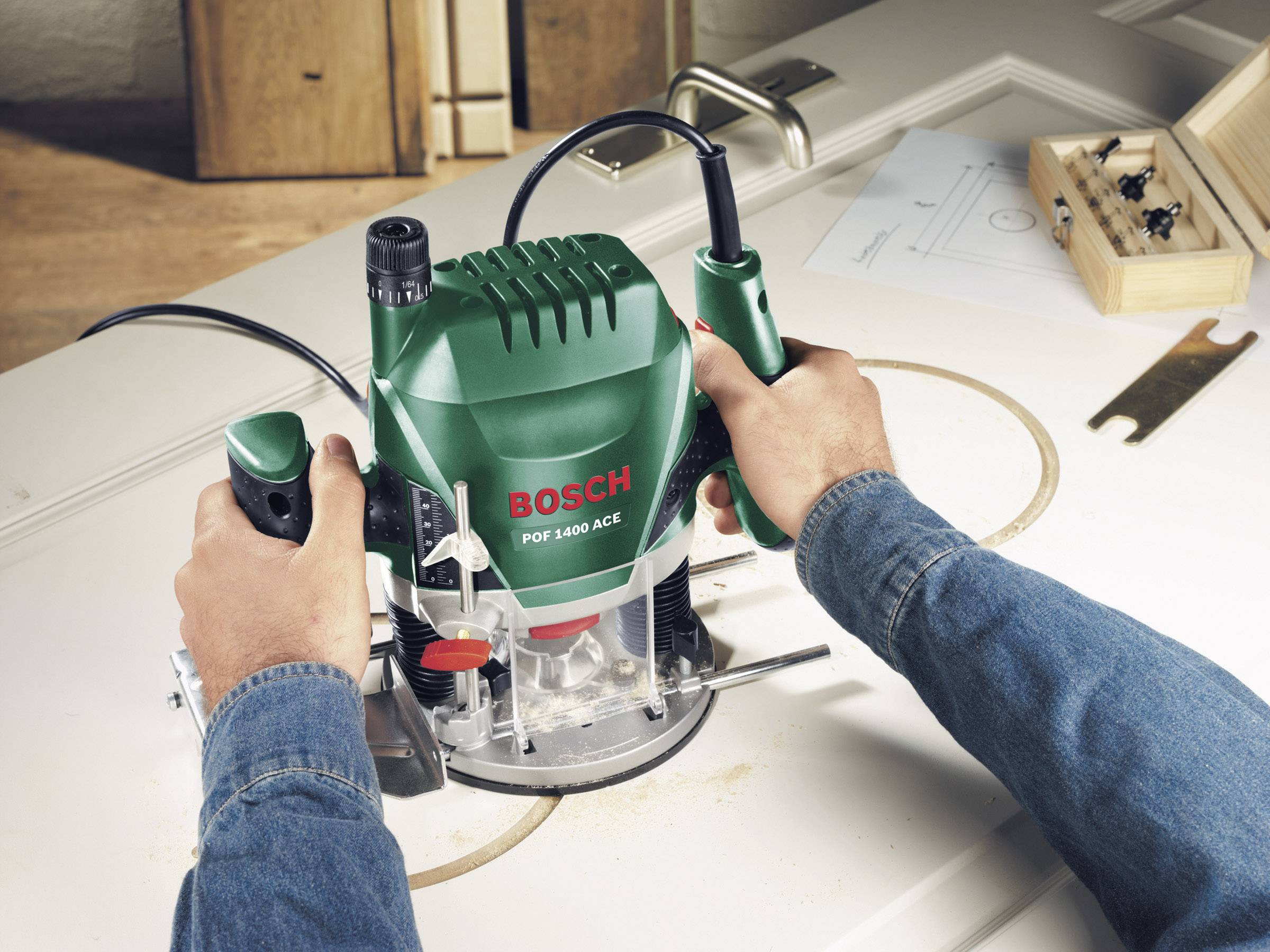 Una persona sta utilizzando una fresatrice Bosch verde su un pannello di legno per creare un taglio circolare.