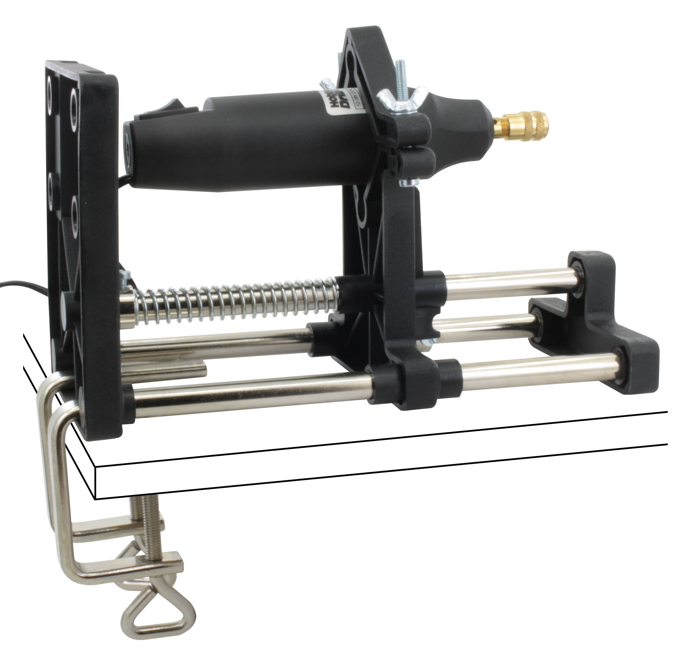 Un dispositivo di pressatura asfaltato viene fissato a un tavolo. Ha molle e aste metalliche ed è apparentemente utilizzato per compiti di pressatura.