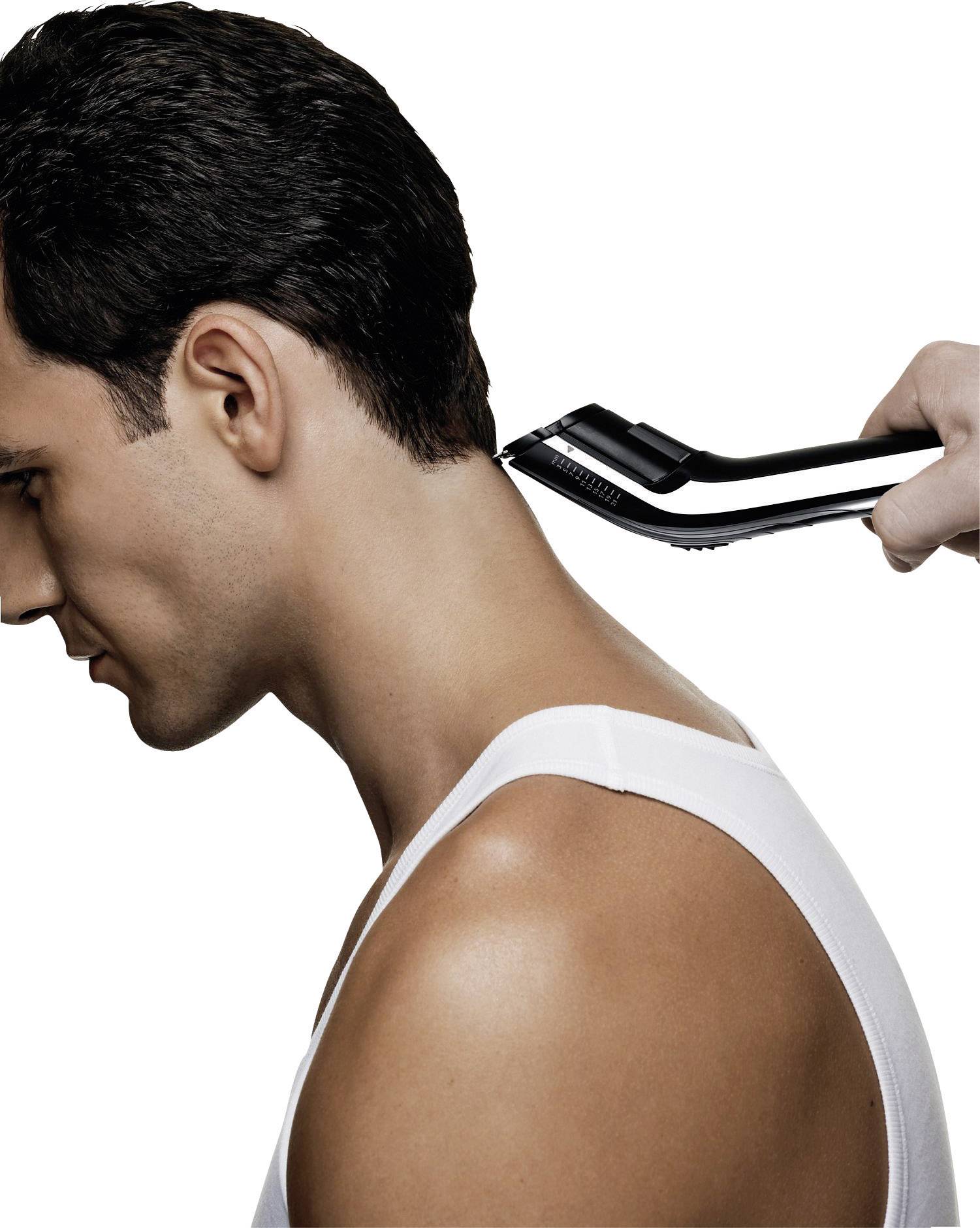 Un uomo sta venendo tagliato i capelli da dietro con un tagliacapelli elettrico. Un rasoio sta rifinendo i capelli nell'area del collo.