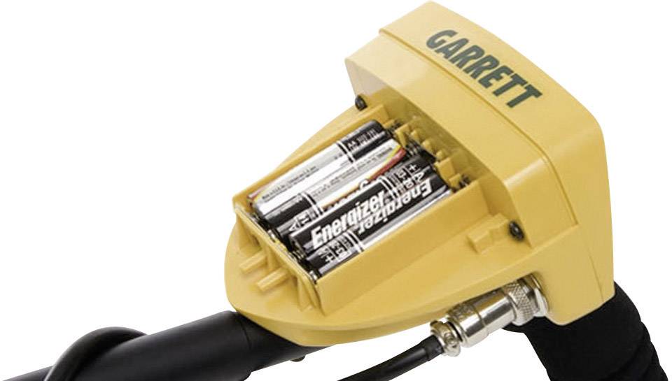 Un metal detector giallo della marca Garrett con il vano batterie aperto che mostra tre batterie AA della marca Energizer.