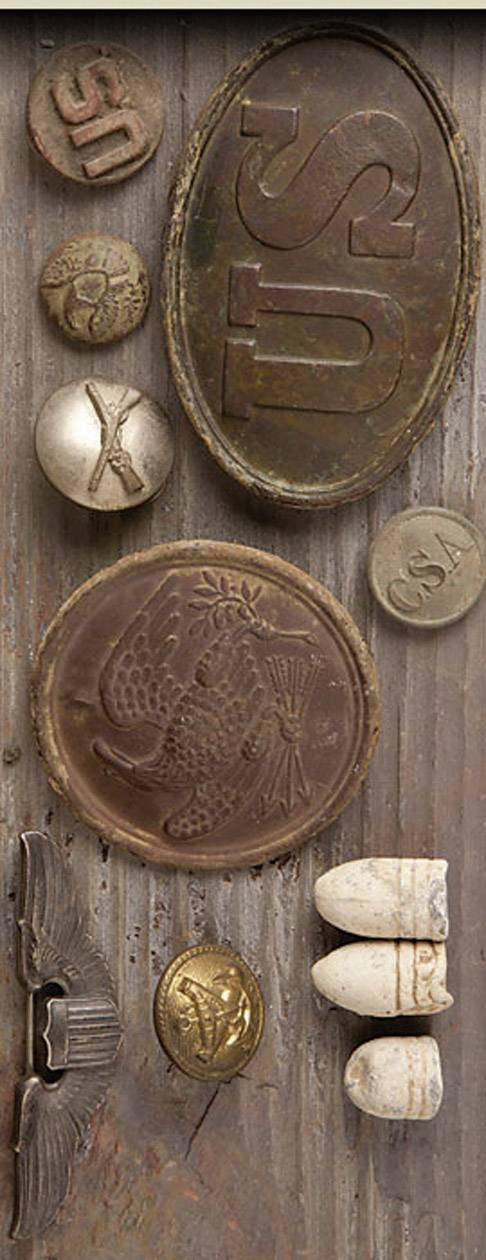 Vari elementi metallici e lapidei impressi su una superficie in legno. Motivi principali: pesci, lettere, simboli.