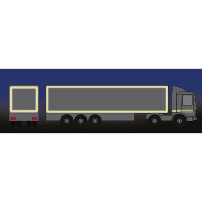 Camion con rimorchio di notte; le strisce riflettenti sui bordi laterali e posteriori risaltano luminose sullo sfondo scuro.