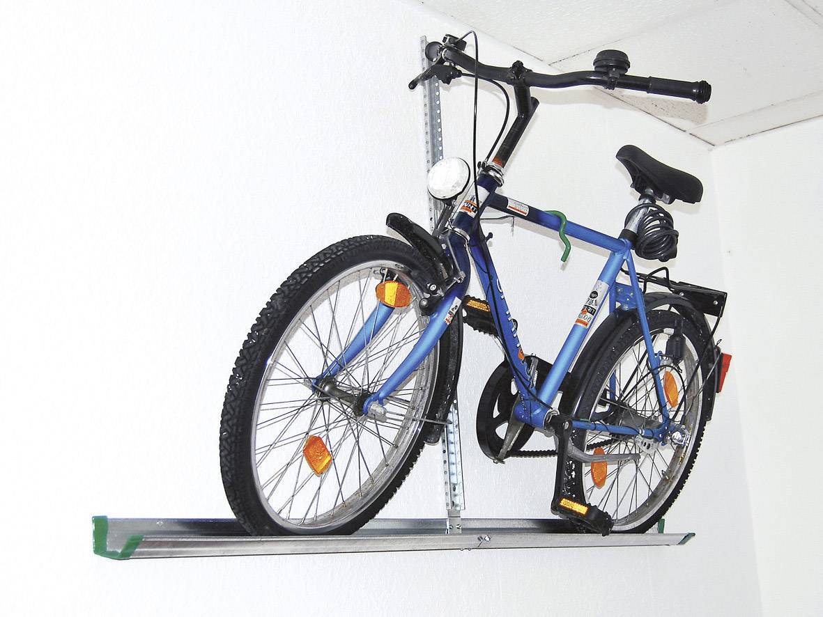 Bicicletta montata su un supporto a parete bianco.