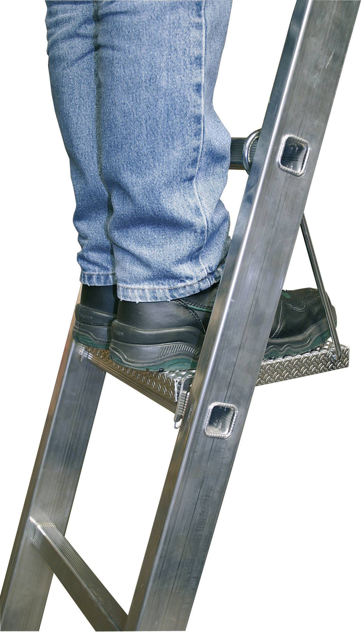 Una persona è in piedi su una scala metallica, sono visibili solo le gambe vestite di jeans e scarpe nere.