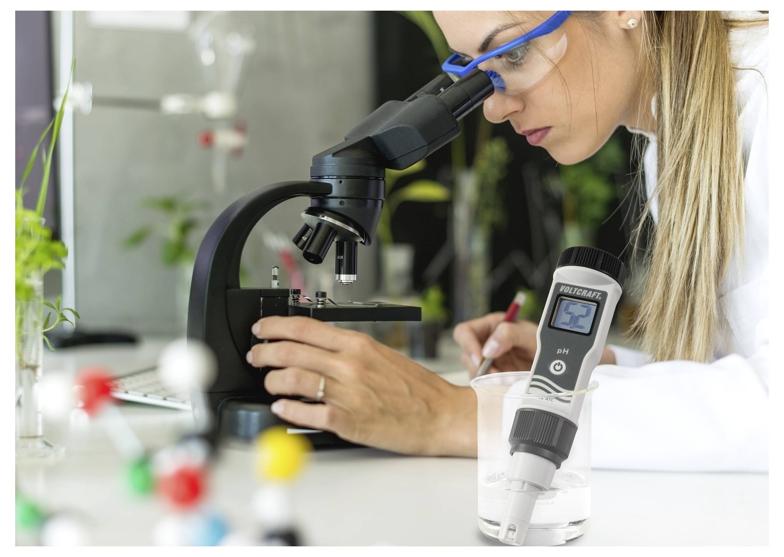 Een wetenschapper met veiligheidsbril onderzoekt een preparaat onder een microscoop in een laboratorium. Een digitale plantenmeter bevindt zich op de voorgrond.