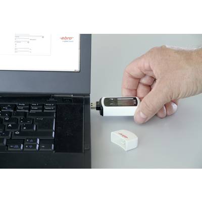 Een persoon steekt een USB-apparaat in een laptop. Op de USB-stick en de bijbehorende deksel staat 'ebro'.