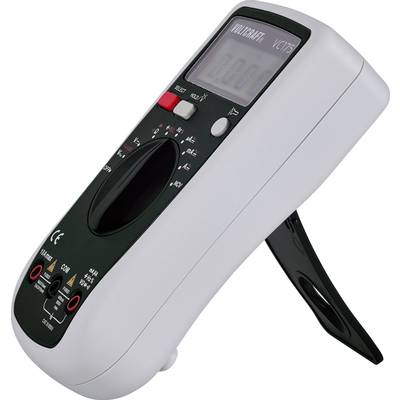 Een digitaal multimeter met een zwart behuizing en een kantelbare standaard, toont spanning aan. Draaiknop en aansluitingen zichtbaar.
