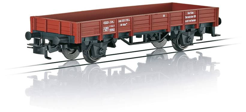 Een model van een rode goedereentreinwagon met zwarte wielen, geplaatst op een reflectief oppervlak.