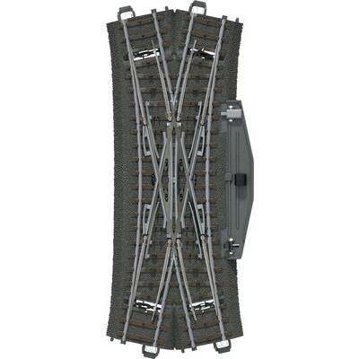 Modelspoorwegtraject met kruising en wissel, bestaande uit meerdere spoorrails en dwarsliggers op een donker grindbed.