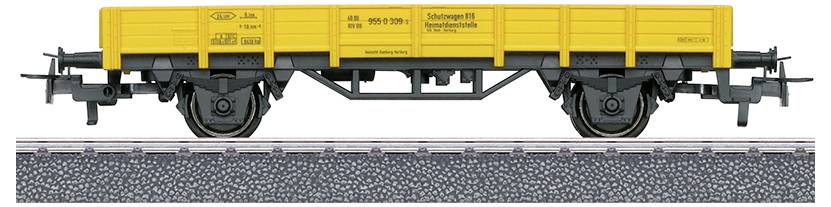 Een modeltrein goederenwagen met een heldergrele gele carrosserie en een zwart onderstel, tentoongesteld op een spoorsectie met grindeldetails.