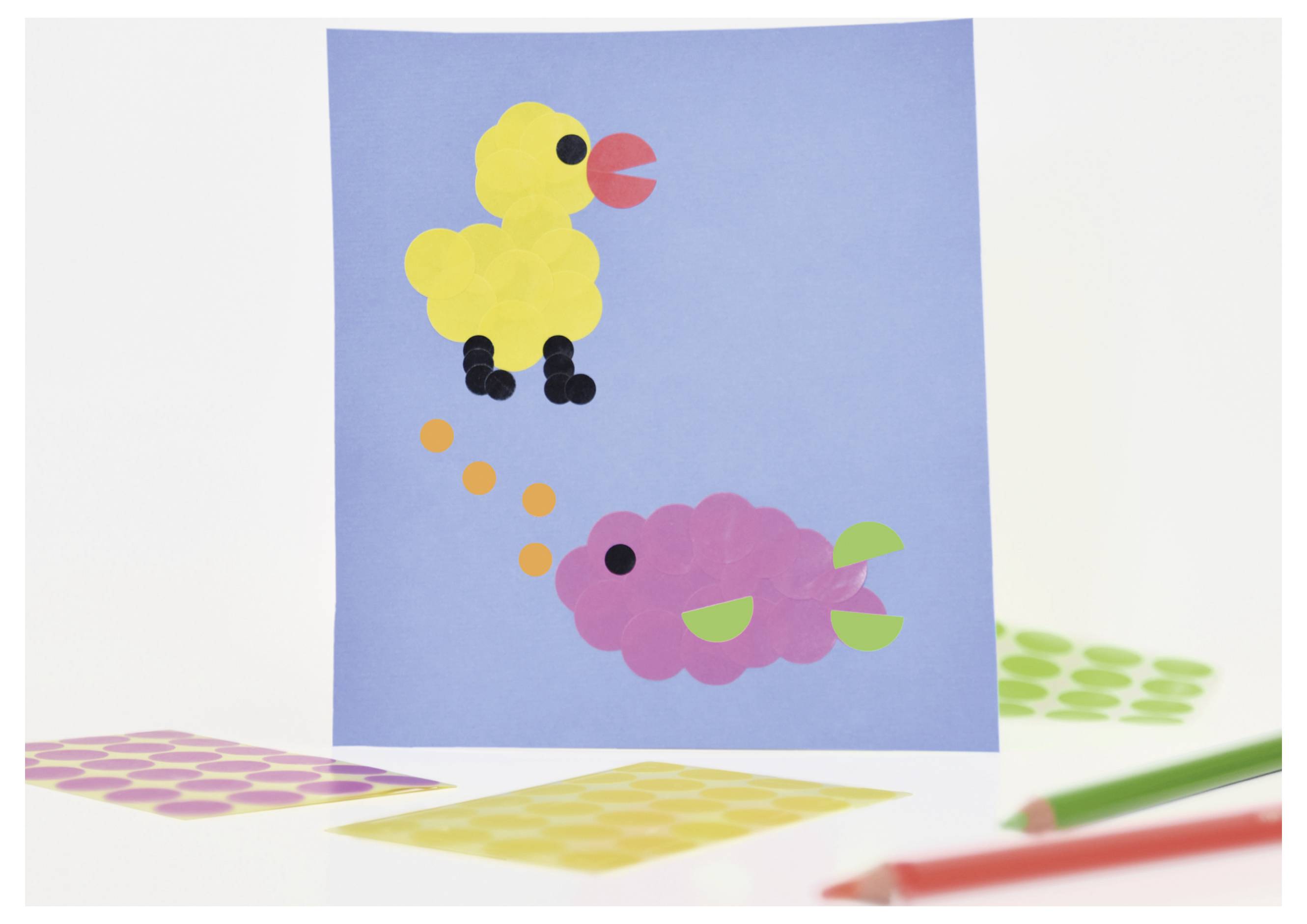 Bastelafbeelding met geel kuiken bovenaan en roze vis onderaan op blauwe achtergrond; omgeven door gekleurde papiervormen en stiften.