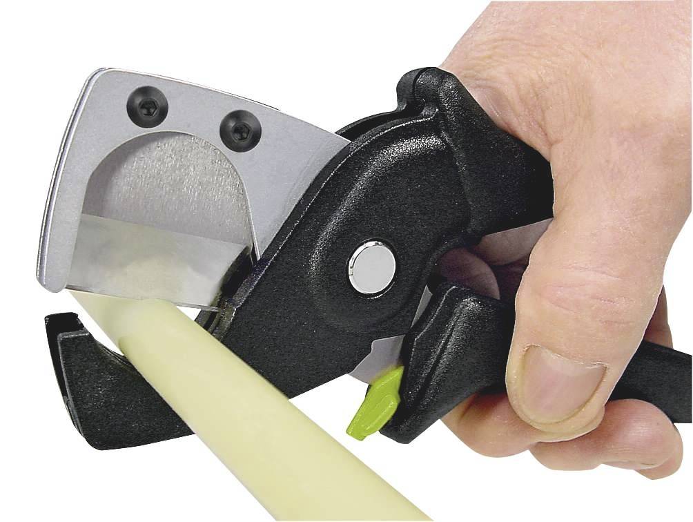 Een hand gebruikt een buizensnijder om een gele buis door te snijden. Het lemmet van de snijder is zilver, de handgreep is zwart.