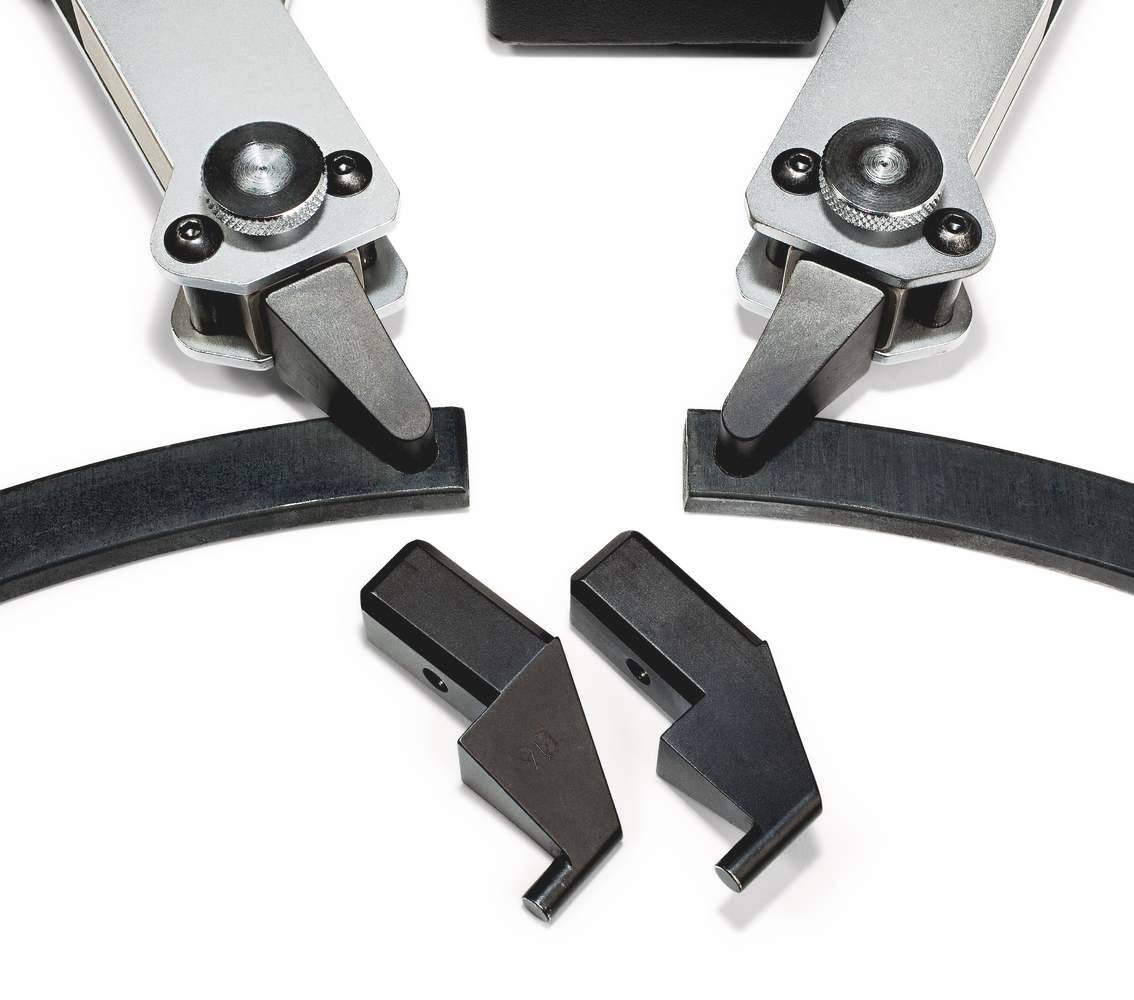 Mechanische grijparmen en onderliggende verwisselbare grijpgereedschappen, weergegeven op een witte achtergrond.