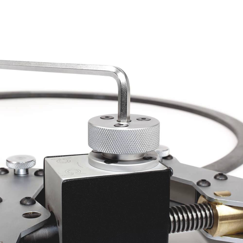 Een metalen meetinstrument met schaal, schroeven en hefboom. Het lijkt te worden gebruikt voor nauwkeurige metingen of aanpassingen.