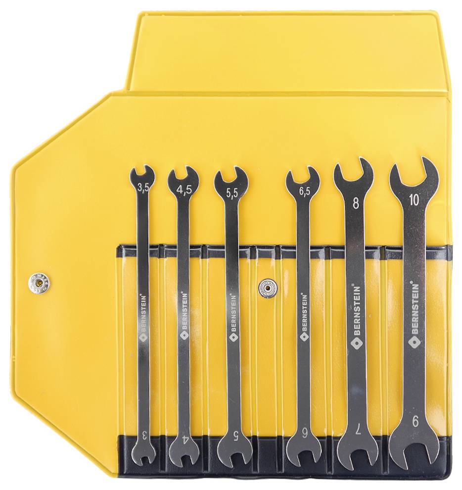 Een set van zeven steeksleutels met afmetingen variërend van 3,5 tot 10 mm, netjes georganiseerd in een gele kunststof houder, gemonteerd aan de muur.