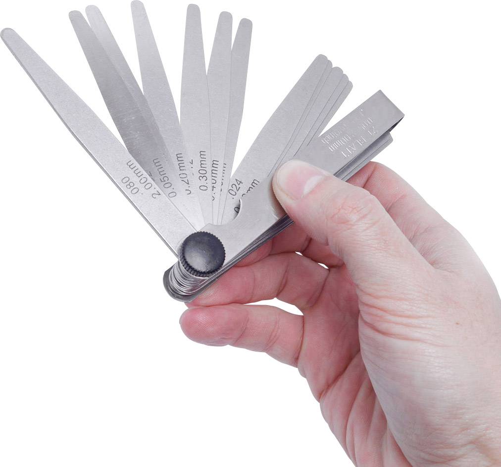 Een hand houdt een voelermaatje met meerdere metalen bladjes vast, die verschillende diktes aangeven voor het meten van spleten en afstanden.