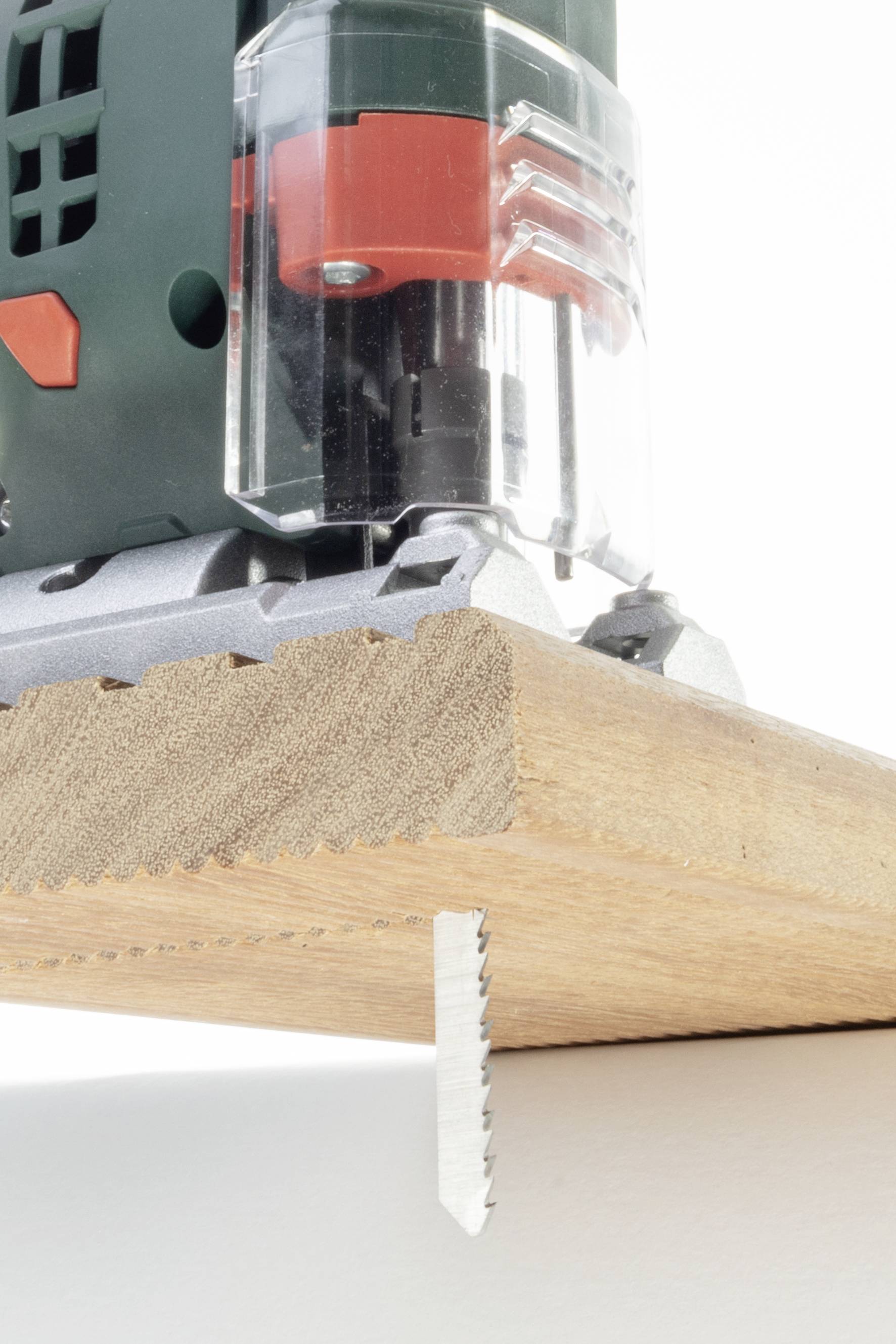 'Accuzaag snijdt door een houten plank. Close-up toont de zaagbladen tijdens het snijproces.'