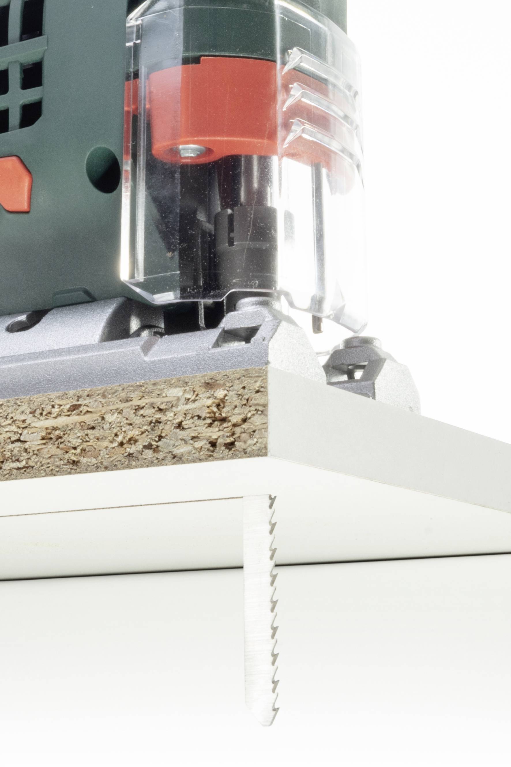 Een decoupeerzaag snijdt precies door een houten plaat die op een witte ondergrond ligt.