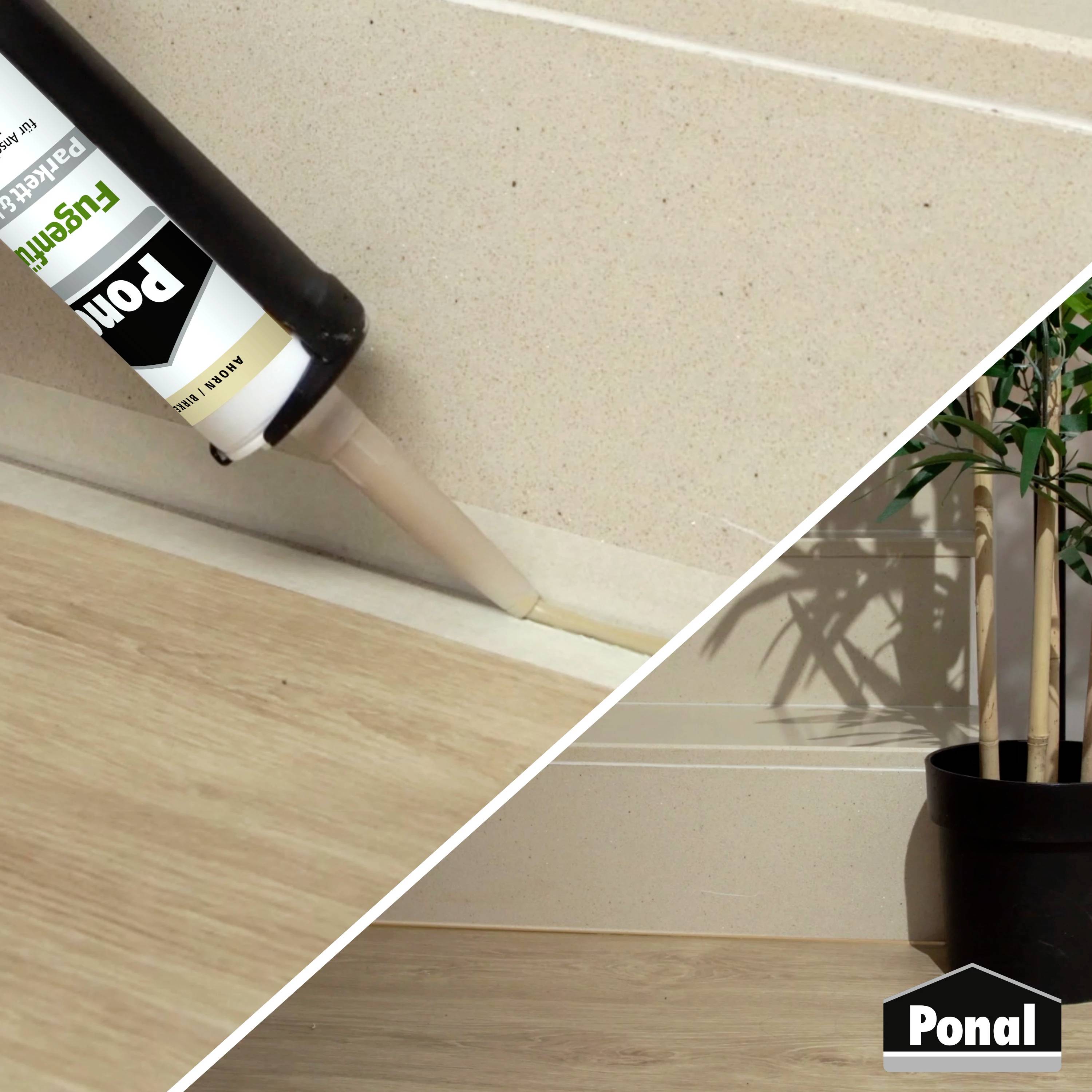 Een cartridge met witte kit wordt aangebracht op een voeg tussen muur en houten vloer; naast de voeg staat een plant.