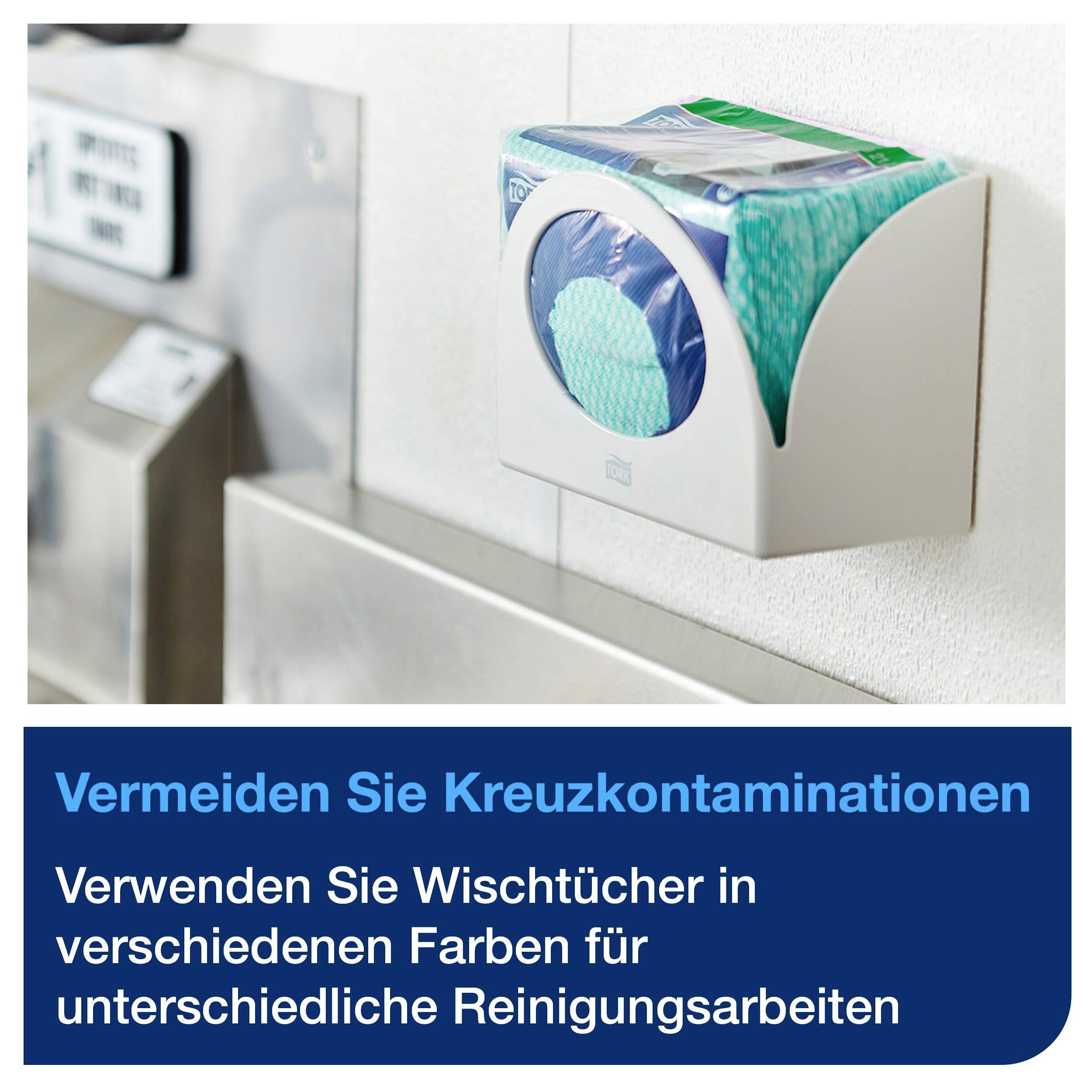 Een dispenser met gekleurde poetsdoeken aan een muur. Opschrift: 'Voorkom kruisbesmetting, gebruik verschillende kleuren.'