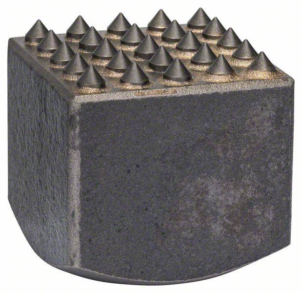 Een grove metalen blok met een bovenzijde van piramideachtige punten, gebruikt als gereedschap voor oppervlaktebewerking.
