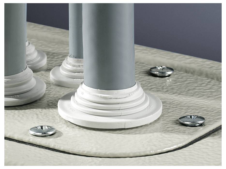 Close-up van grijze cilindrische buizen gemonteerd op witte sokkels op een gestructureerde metalen plaat, vastgemaakt met schroeven.