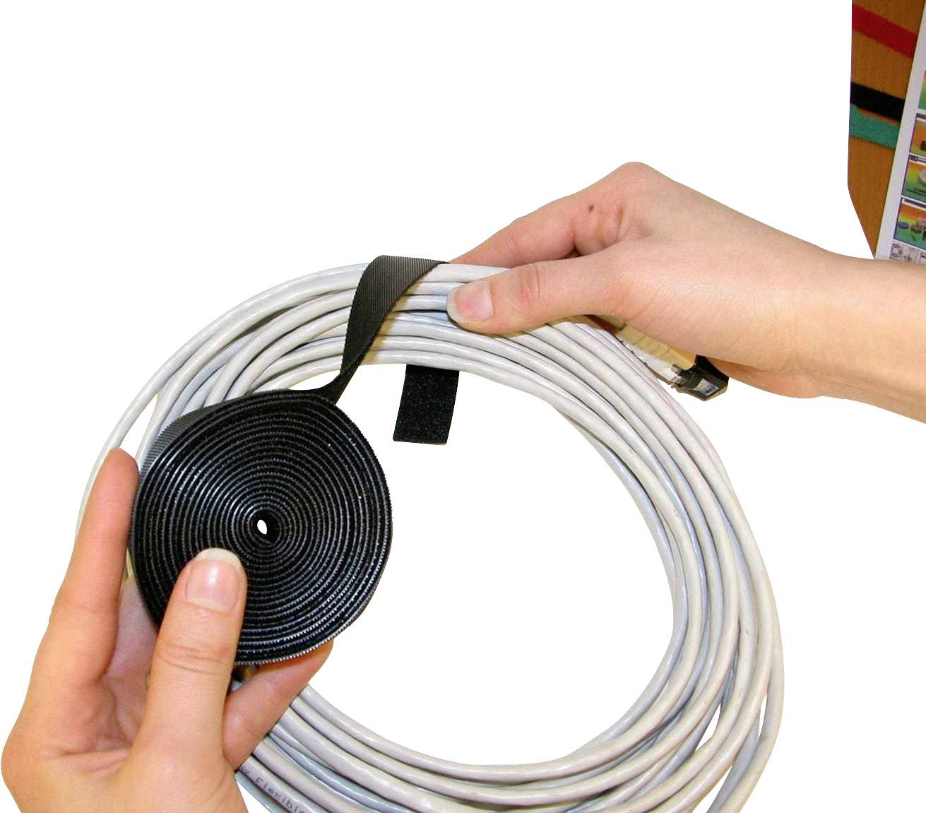 Een persoon houdt een opgerolde kabelset vast, die met een klittenband is vastgemaakt. Het klittenband wordt om de kabel gewikkeld.