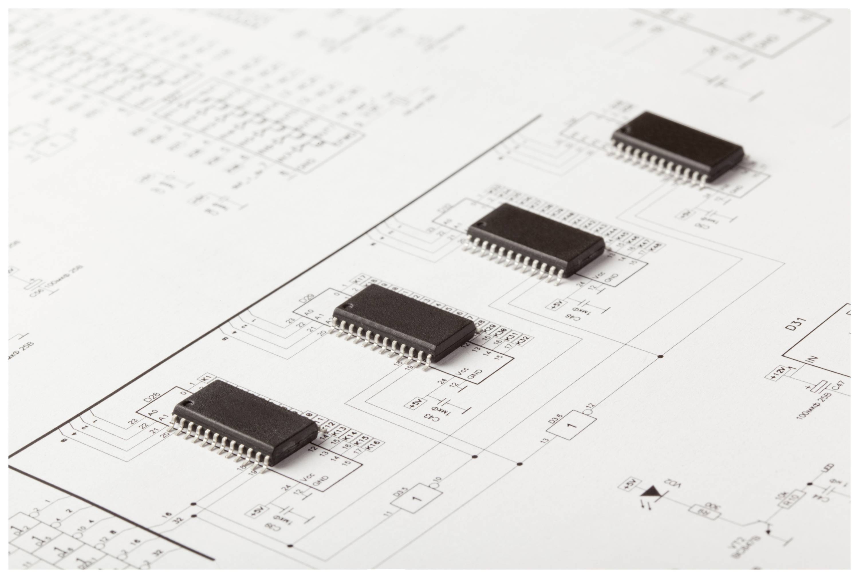 Vier microchips op een technische schematekening die gedetailleerde elektronische schakelingen weergeeft.