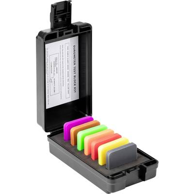 Een zwarte doos met zes testblokken in verschillende kleuren, geplaatst in een schuimrubberen inzetstuk. Op het deksel een papier met instructies.