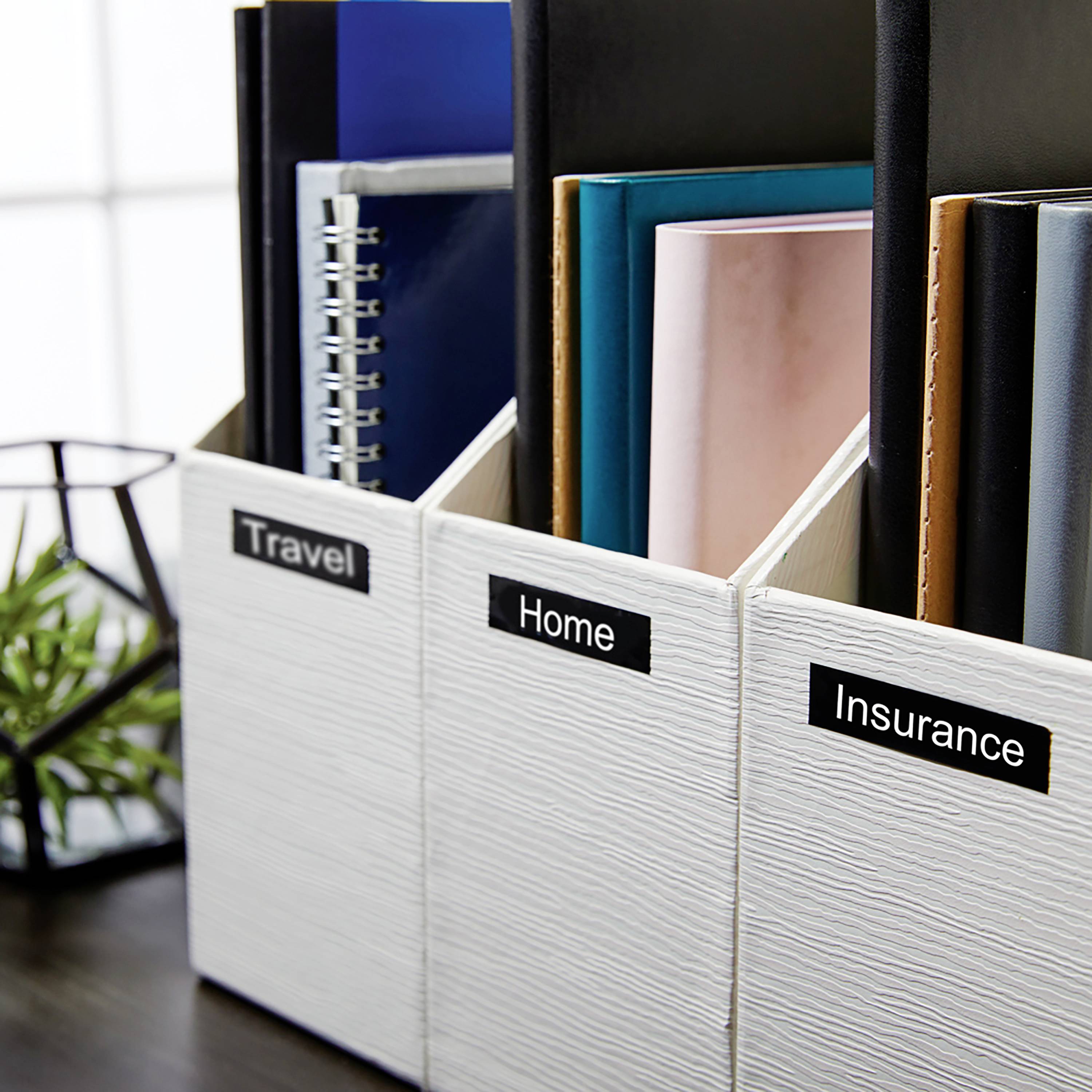 Drie mappen met etiketten 'Reizen', 'Thuis' en 'Verzekering' staan in een schap. Ze zijn gevuld met documenten en papieren.