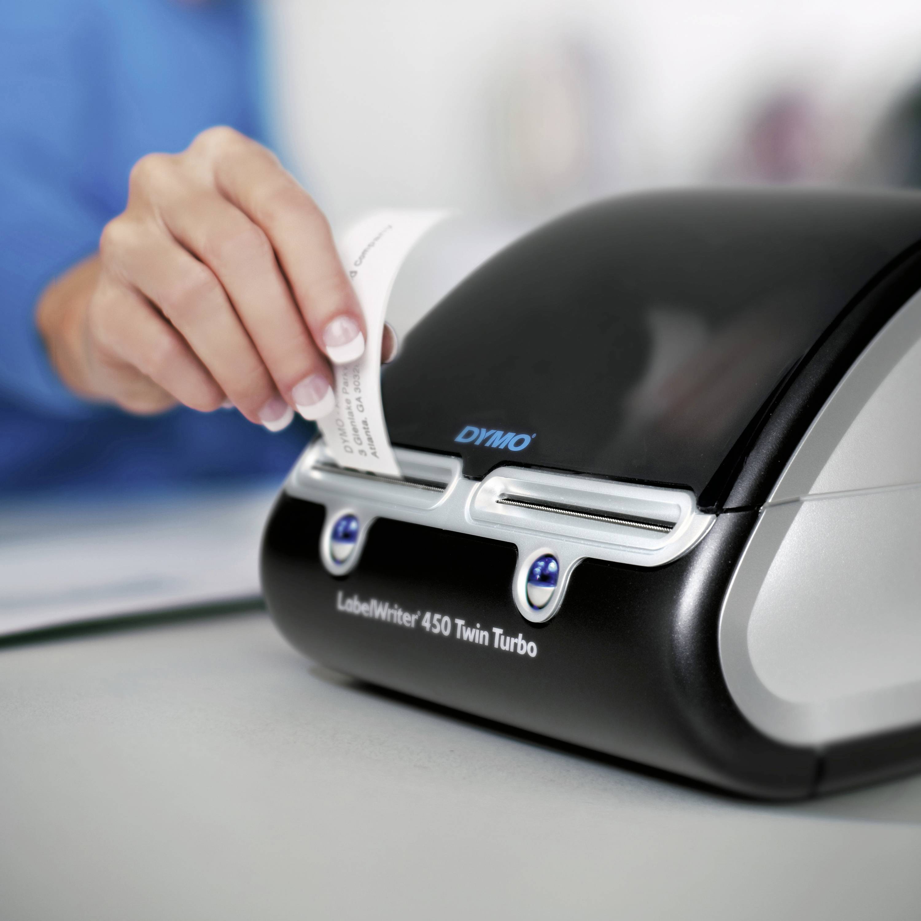 Een persoon gebruikt een labelprinter om een klein etiket af te drukken. Er wordt een LabelWriter 450 Twin Turbo gebruikt.