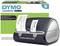Dymo LabelWriter 450 Twin Turbo naast de verpakking. Drukt adresetiketten met de naam 'Peter Smith, New York, NY 10004'.