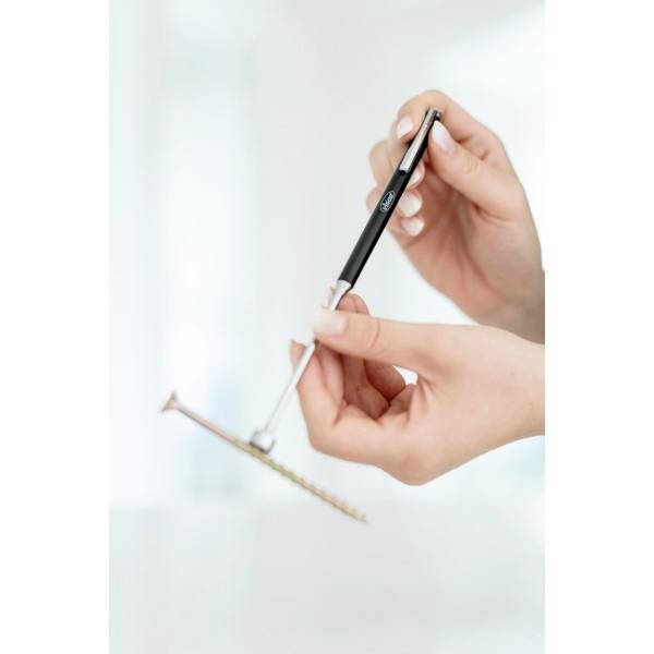 Een persoon houdt een zwart-zilveren pen en een goudkleurige smartphone vast in zijn handen voor een onscherpe achtergrond.