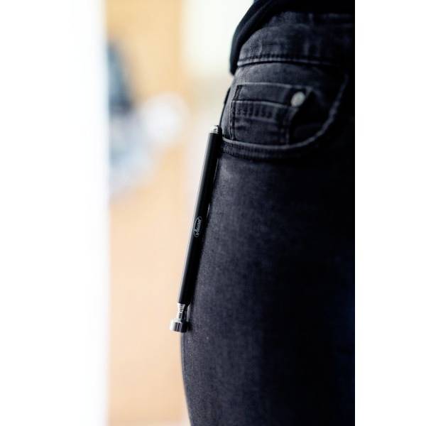 Een zwarte spijkerbroek met een pen die in de broekzak steekt. De focus ligt op de pen.