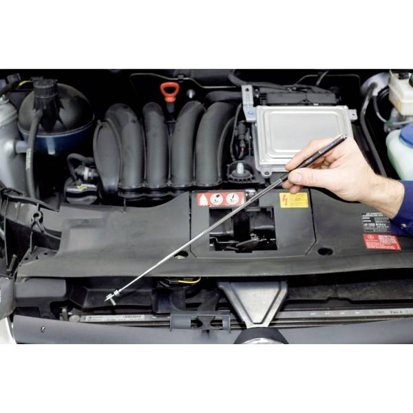 'Een hand trekt de oliepeilstok uit een auto om het oliepeil te controleren.'