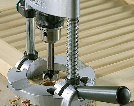 'Close-up van een boormachine tijdens het boren van een rond gat in een houten plank.'