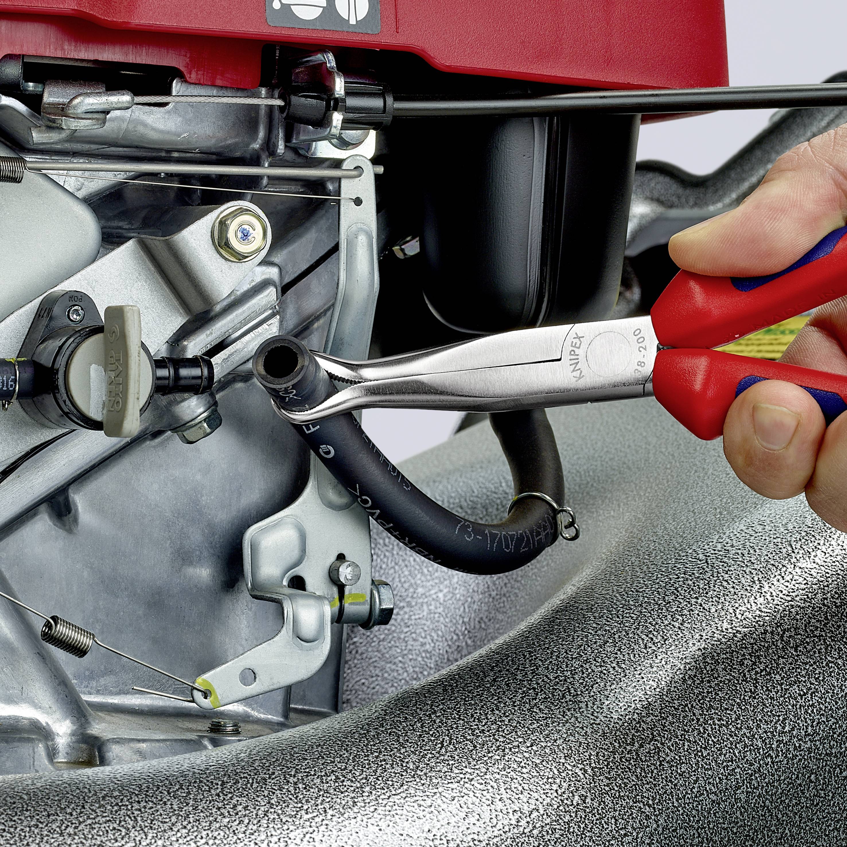 Een steeksleutel wordt gebruikt om een schroef op een motor vast te draaien. Een hand houdt het gereedschap vast.