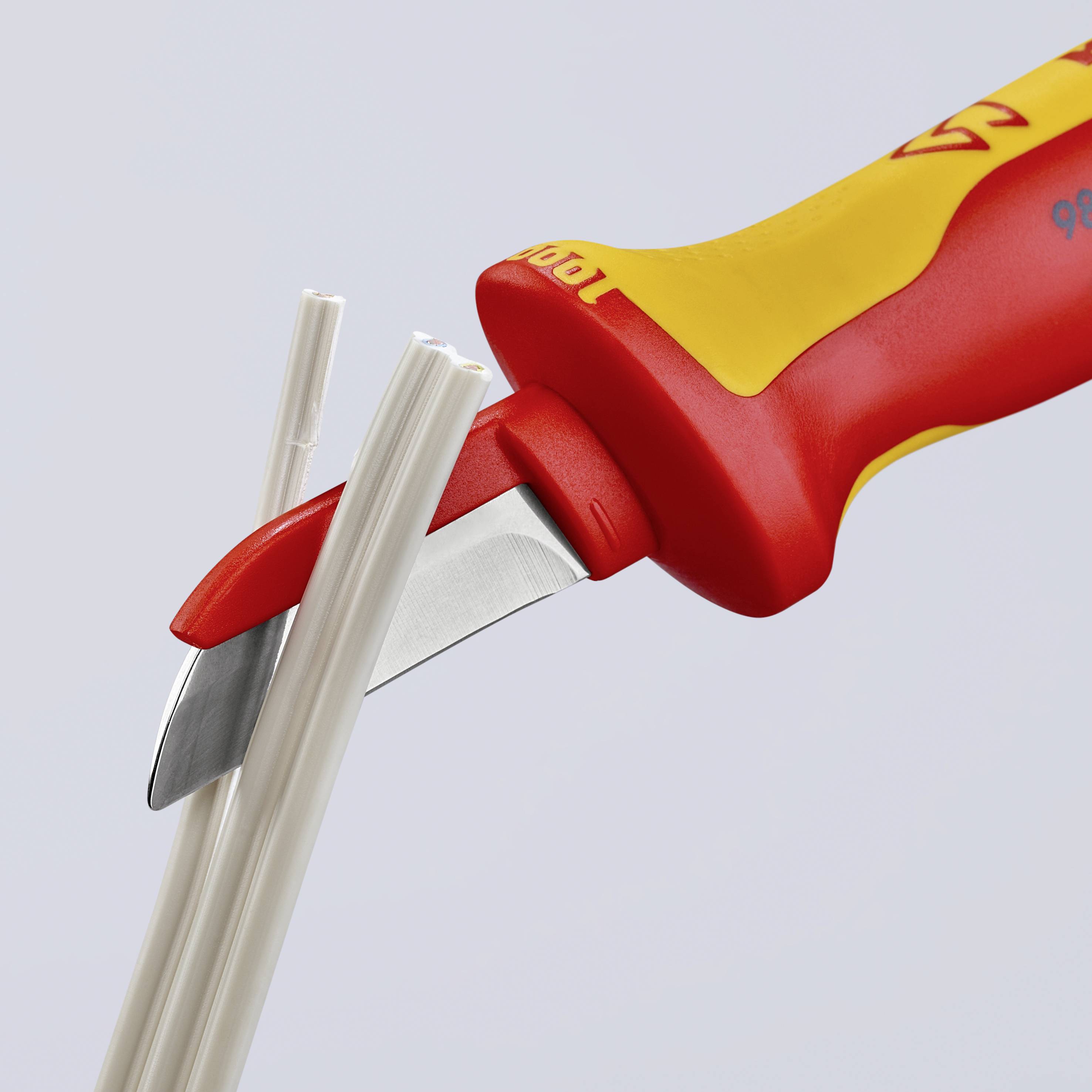 Een gereedschap met een rood en geel handvat snijdt witte kabels. Het wordt gebruikt voor het strippen van elektrische kabels.