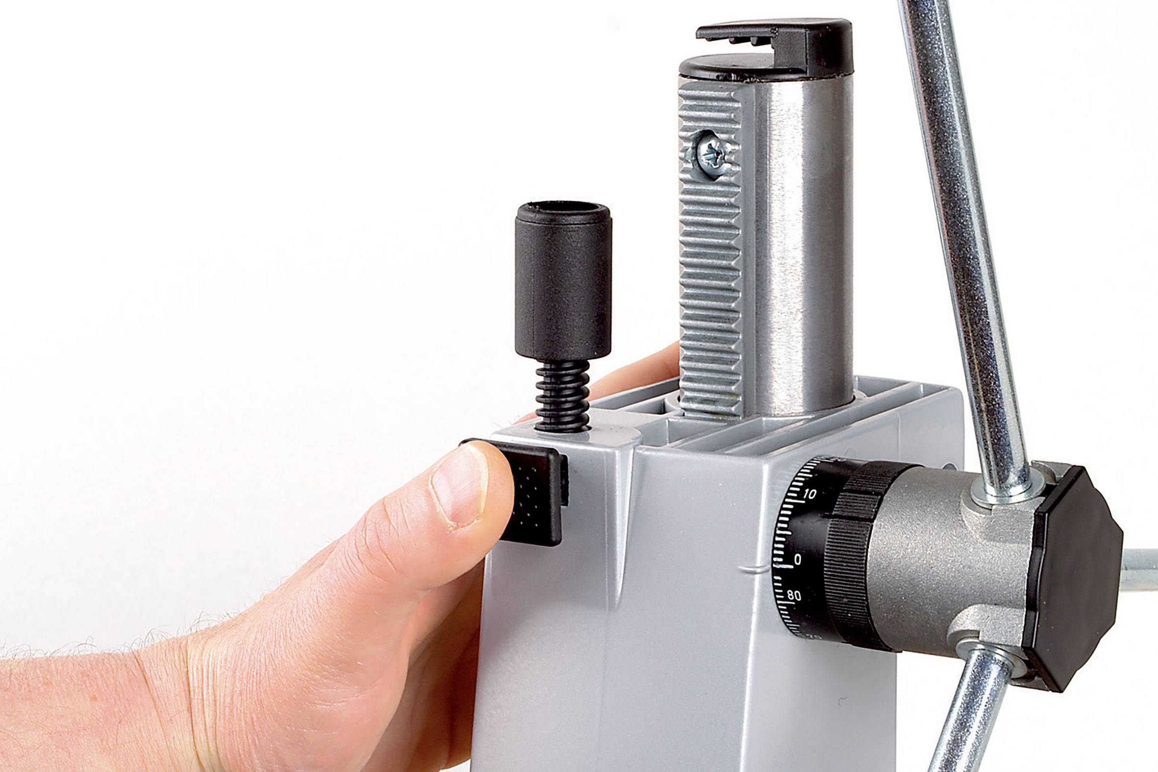 Hand bedient een mechanische inrichting met een hefboom en een knop.