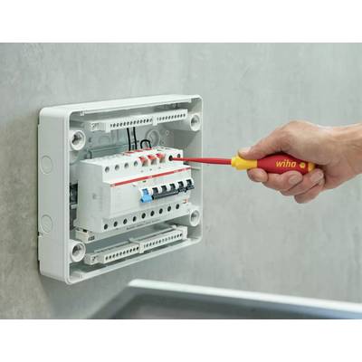 'Een hand draait met een schroevendraaier de schakelaar van een elektrische zekering in een schakelkast.'